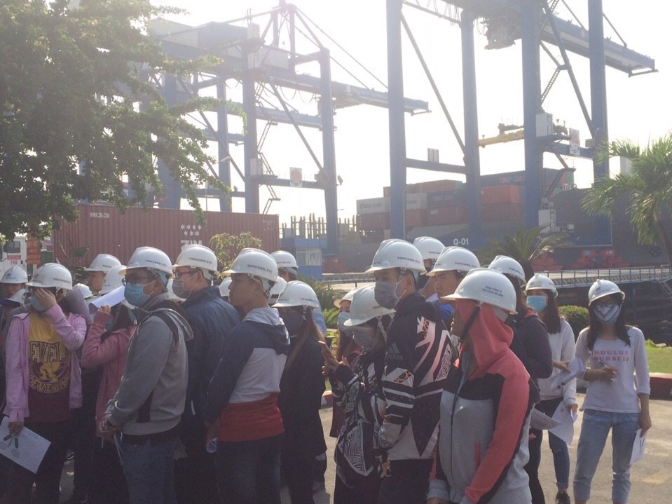 Students are listening to the instructor presenting the information regarding ships of foreign shipping lines currently operated at the port and the modern systems of berths and cranes of Cat Lai port.