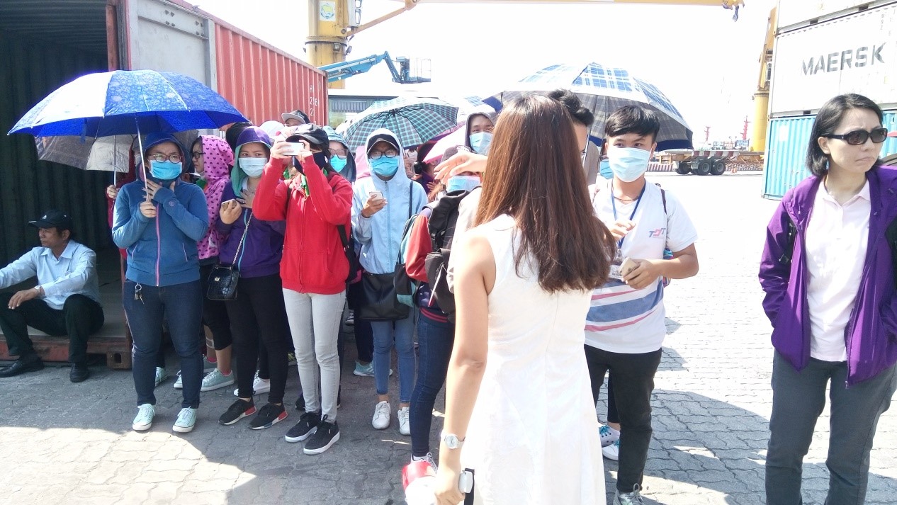 Students are observing a process of stuffing goods into a container for seaway transport at the Container Freight Station (CFS).